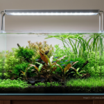 Uma luminária LED de design moderno e fino, feita de alumínio, suspensa sobre um aquário plantado de água doce. A luz branca brilhante ilumina intensamente as diversas plantas aquáticas, com destaque para a Cryptocoryne central (inspirada na imagem original) que exibe tons de verde e bronze. Peixes Neon Tetra nadam entre a vegetação, tudo em um cenário limpo e profissional.